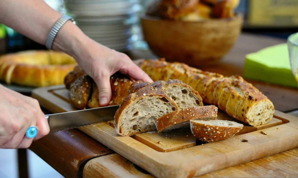 Mano che affetta pane integrale